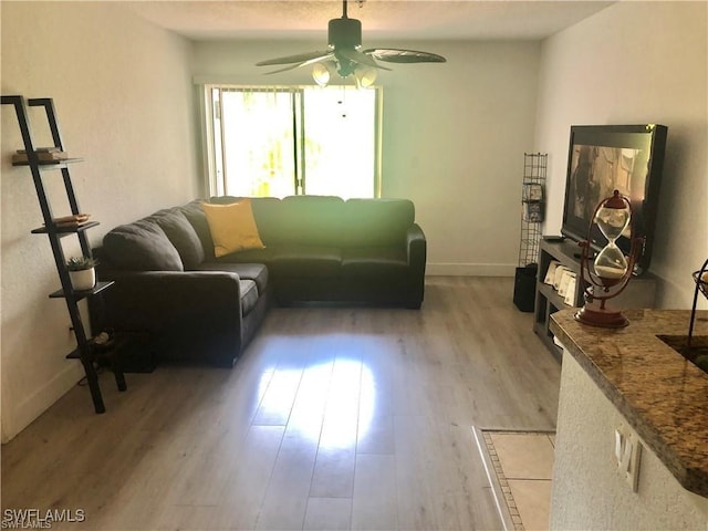 living room with light hardwood / wood-style flooring and ceiling fan