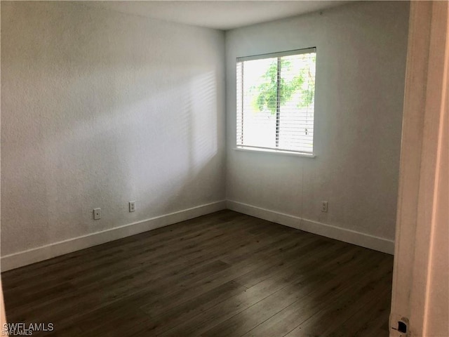 unfurnished room featuring dark hardwood / wood-style floors