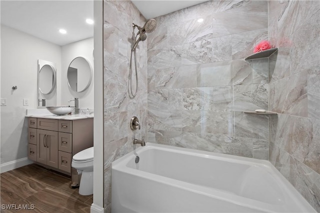 full bathroom with tiled shower / bath, vanity, and toilet