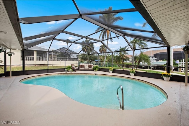 view of pool with a patio area and glass enclosure