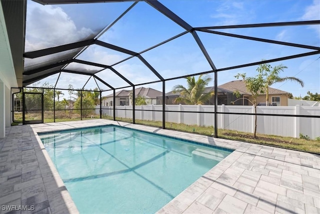 view of swimming pool featuring a patio and a lanai