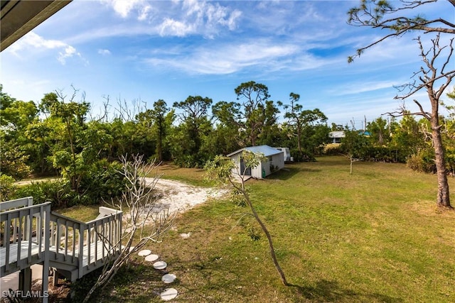 view of yard featuring an outdoor structure and a wooden deck