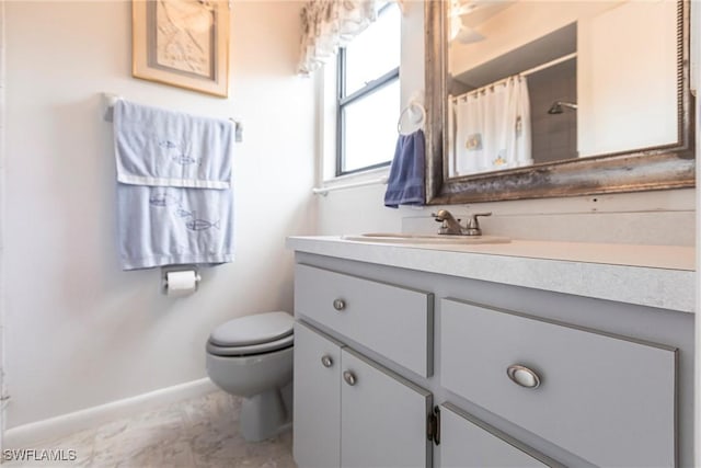 full bathroom featuring toilet, a shower with curtain, baseboards, and vanity