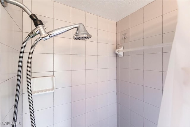 bathroom featuring a textured ceiling and tiled shower