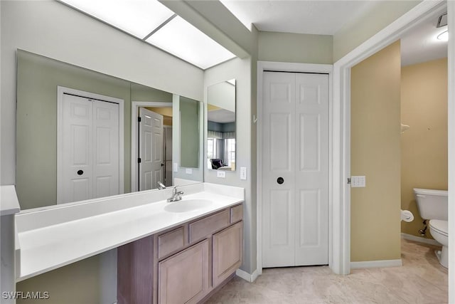 bathroom featuring vanity, toilet, and a skylight