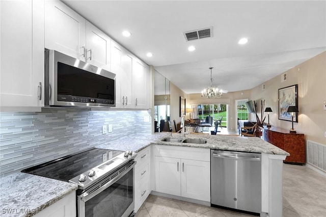 kitchen with white cabinetry, appliances with stainless steel finishes, kitchen peninsula, and sink