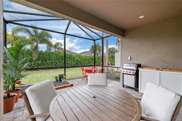 view of patio / terrace with area for grilling, sink, and a lanai