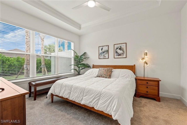 bedroom featuring crown molding, ceiling fan, a raised ceiling, and light carpet