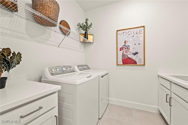 washroom featuring light tile patterned floors, sink, cabinets, and independent washer and dryer