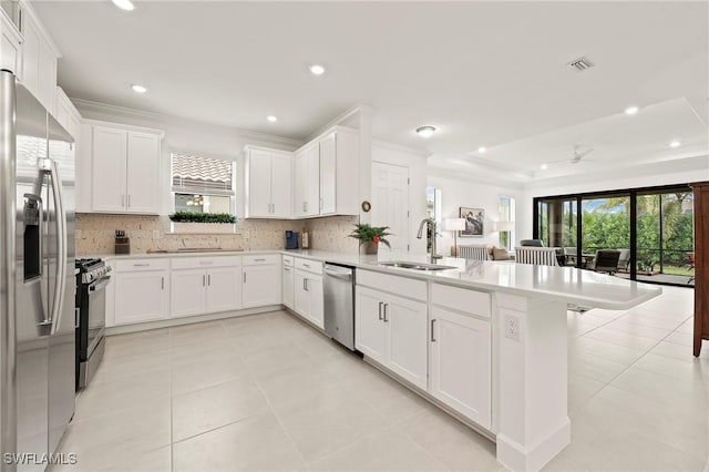 kitchen with stainless steel appliances, white cabinetry, sink, and tasteful backsplash