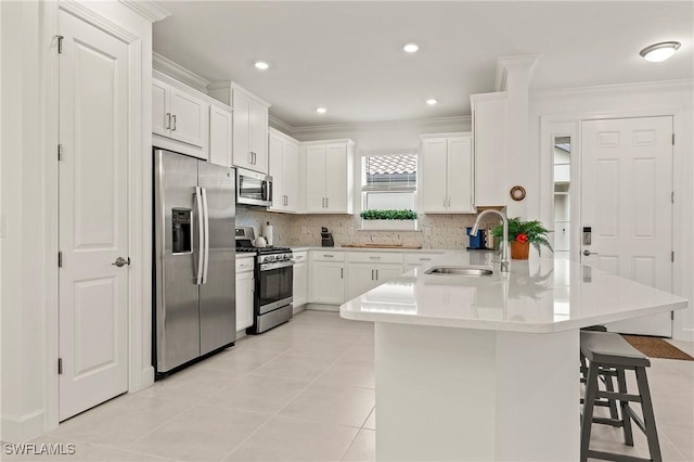 kitchen featuring sink, a breakfast bar area, appliances with stainless steel finishes, white cabinets, and kitchen peninsula