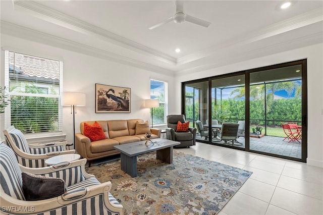 living room featuring a raised ceiling, crown molding, light tile patterned floors, and ceiling fan