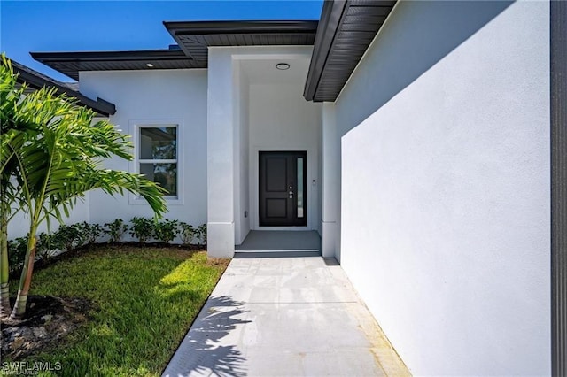 doorway to property with a lawn