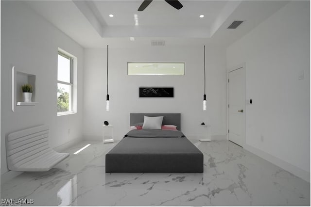 unfurnished bedroom featuring a raised ceiling and ceiling fan