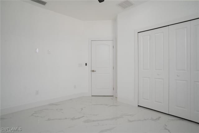 unfurnished bedroom with ceiling fan and a closet