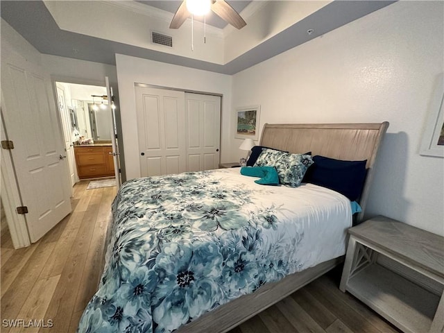 bedroom featuring ceiling fan, light hardwood / wood-style floors, and a closet