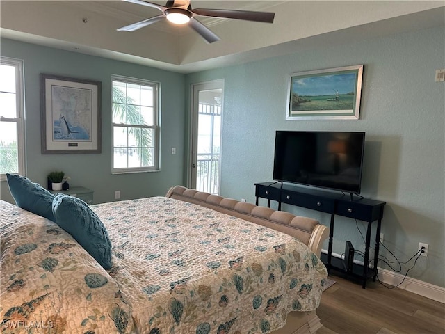 bedroom with multiple windows, hardwood / wood-style floors, and ceiling fan