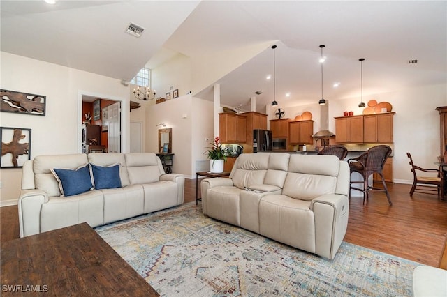 living room with high vaulted ceiling and light hardwood / wood-style flooring