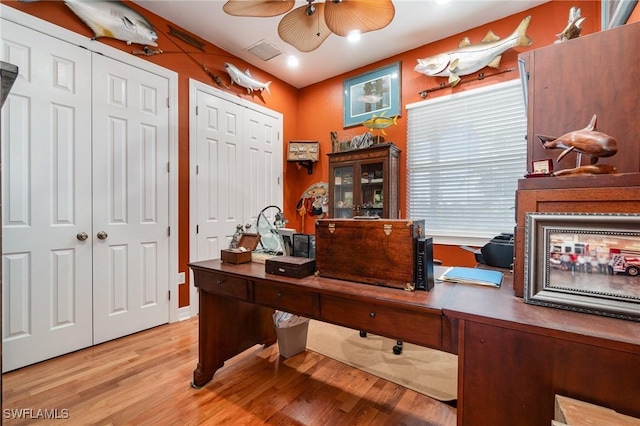 home office with light hardwood / wood-style floors and ceiling fan