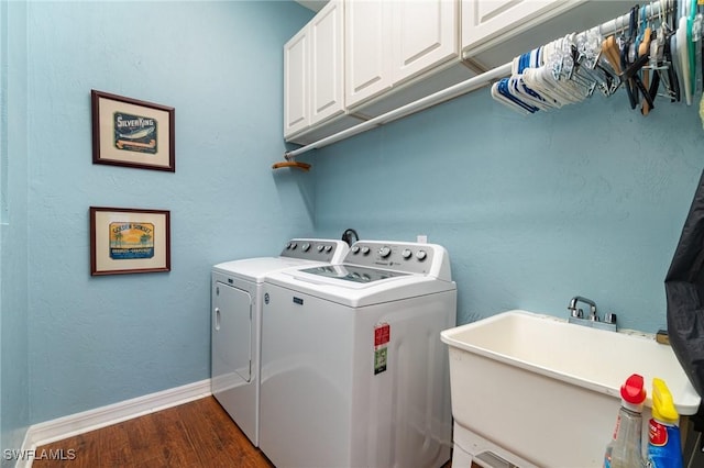 clothes washing area featuring cabinets, dark hardwood / wood-style floors, sink, and washer and dryer