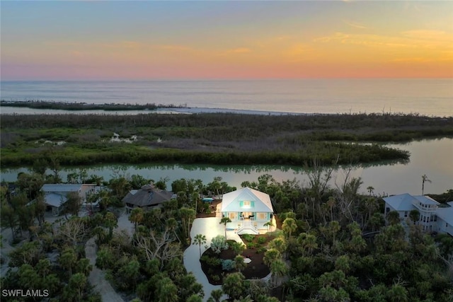 aerial view at dusk featuring a water view