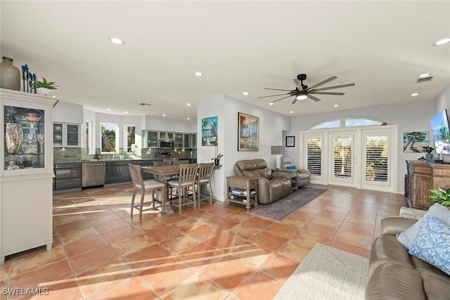 living room with light tile patterned floors, a healthy amount of sunlight, and ceiling fan