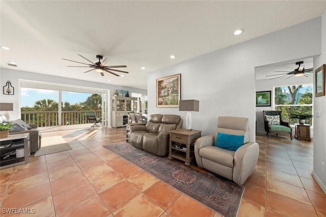 living room featuring a wealth of natural light, ceiling fan, and light tile patterned flooring