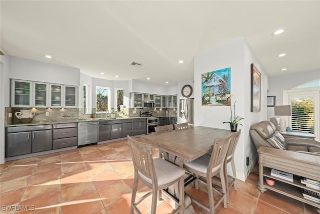 dining room with sink, a wealth of natural light, and light tile patterned floors