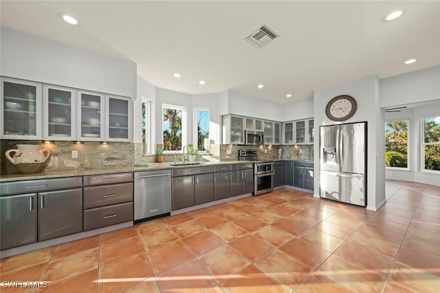 kitchen featuring light stone counters, appliances with stainless steel finishes, sink, and a wealth of natural light