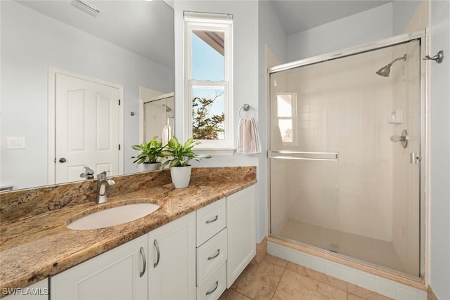 bathroom featuring vanity, an enclosed shower, and tile patterned floors