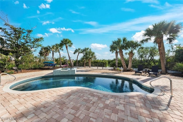 view of pool with a patio and an in ground hot tub