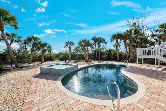 view of swimming pool featuring a patio and an in ground hot tub