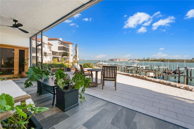 view of patio / terrace featuring a water view, boat lift, a ceiling fan, and a boat dock