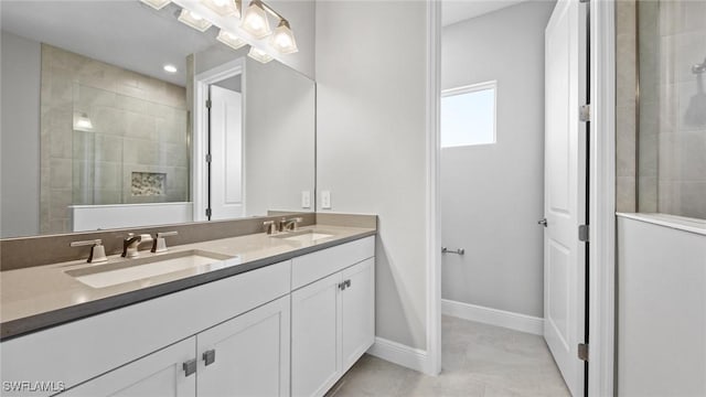 bathroom featuring tiled shower and vanity