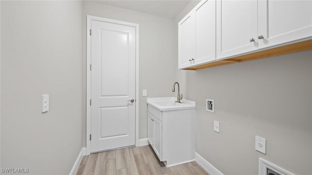 clothes washing area with washer hookup, sink, cabinets, and light wood-type flooring