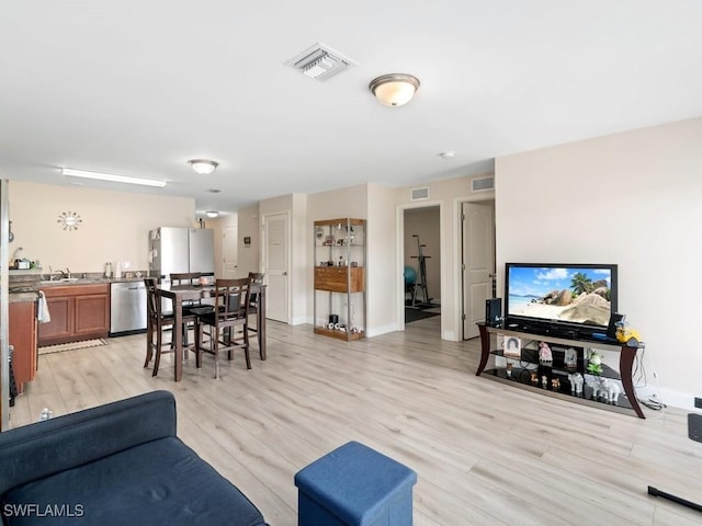 living room featuring sink and light hardwood / wood-style flooring