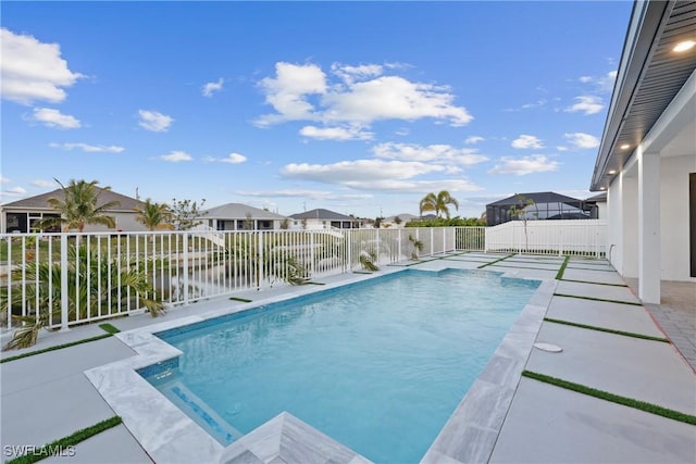 view of pool with a water view and a patio