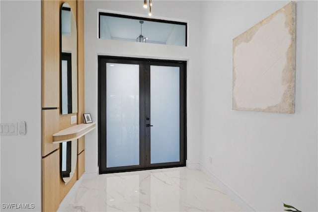 entrance foyer with marble finish floor and baseboards