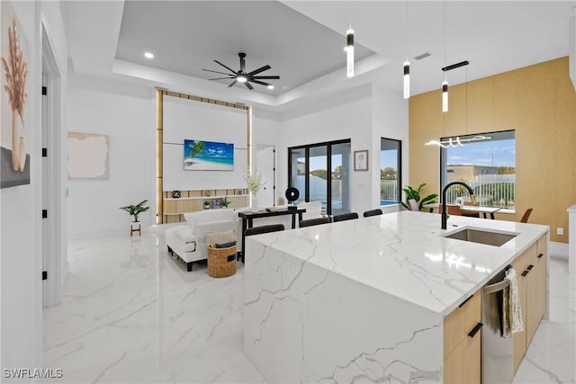 kitchen featuring a sink, modern cabinets, a raised ceiling, and marble finish floor