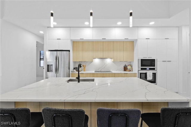 kitchen with modern cabinets, black appliances, a kitchen breakfast bar, a spacious island, and decorative backsplash