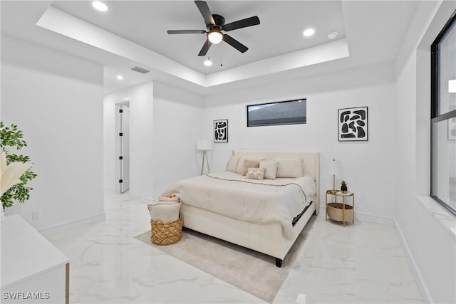 bedroom featuring baseboards, a raised ceiling, and marble finish floor