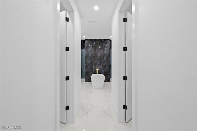 corridor with recessed lighting and marble finish floor