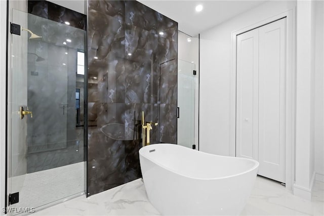 full bath with recessed lighting, a stall shower, a freestanding bath, tile walls, and marble finish floor