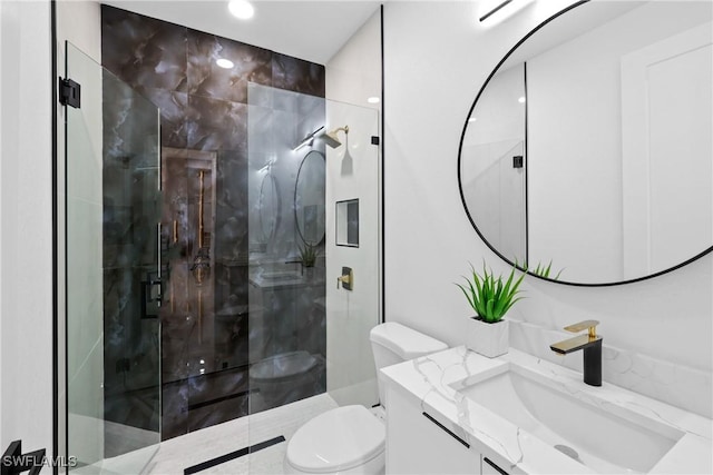 bathroom with a shower stall, toilet, and vanity