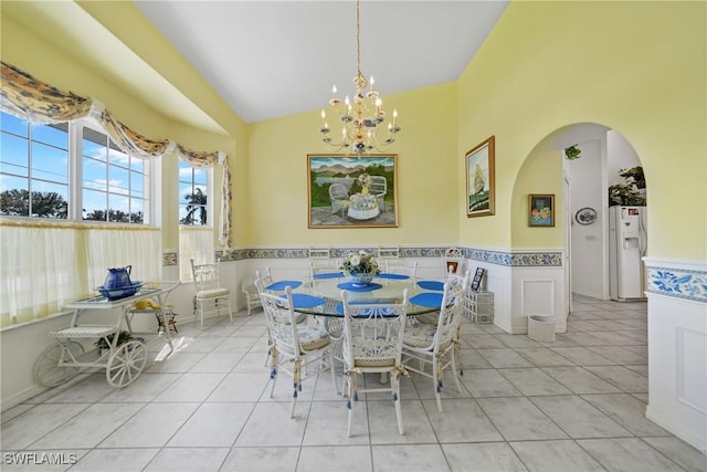 dining area featuring an inviting chandelier, lofted ceiling, and light tile patterned floors