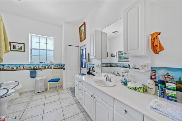 bathroom featuring a bidet, tile patterned flooring, vanity, a textured ceiling, and toilet