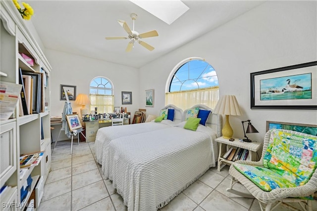 bedroom with light tile patterned floors, ceiling fan, and a skylight