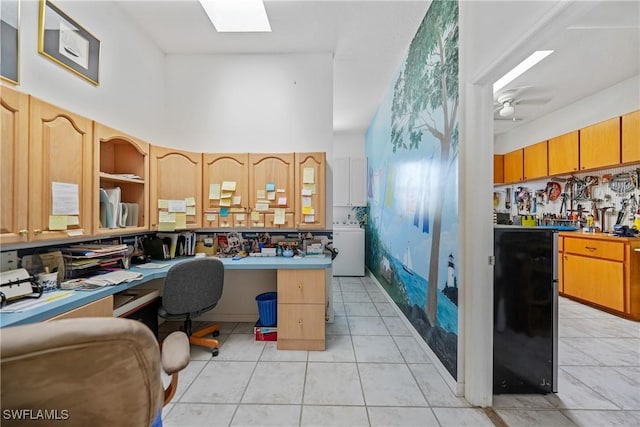 tiled office with washer / clothes dryer, a towering ceiling, a skylight, and ceiling fan