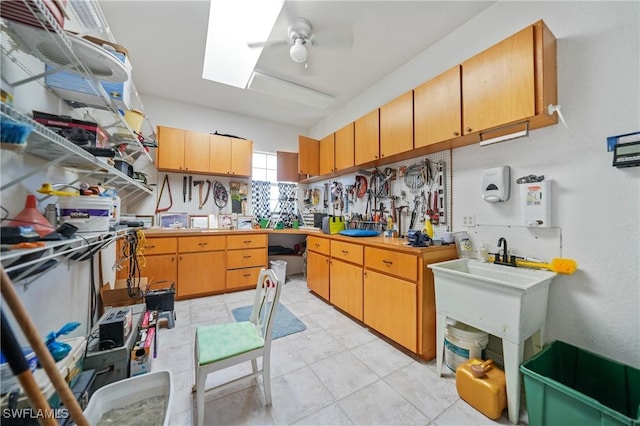 kitchen featuring ceiling fan and a skylight