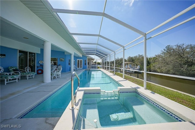 view of swimming pool with a lanai, a patio area, and an in ground hot tub